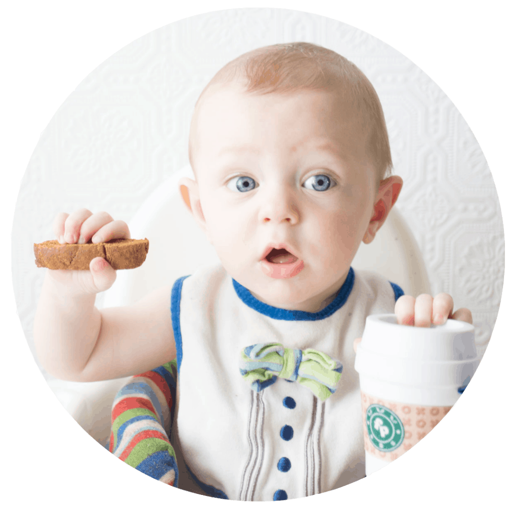 Baby holding pumpkin spice biscotti with Fisher Price Coffee Cup teething toy